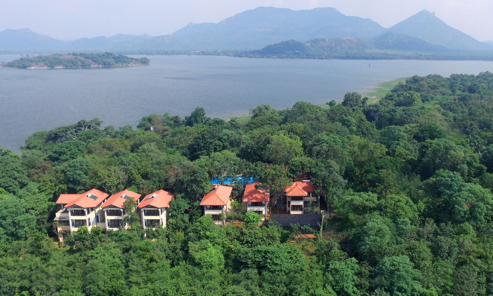 Aerial view of Lake Lodge villas in the forest above Kandalama Lake, with mountains beyond